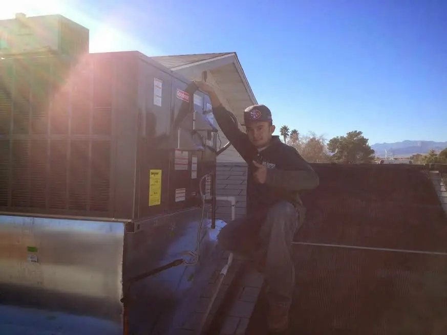 HVAC technician performing AC Tune-Up on a rooftop unit in Columbiana